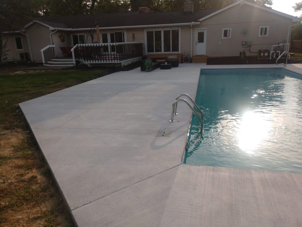 Fiberglass pool with white broom patio surround 48346